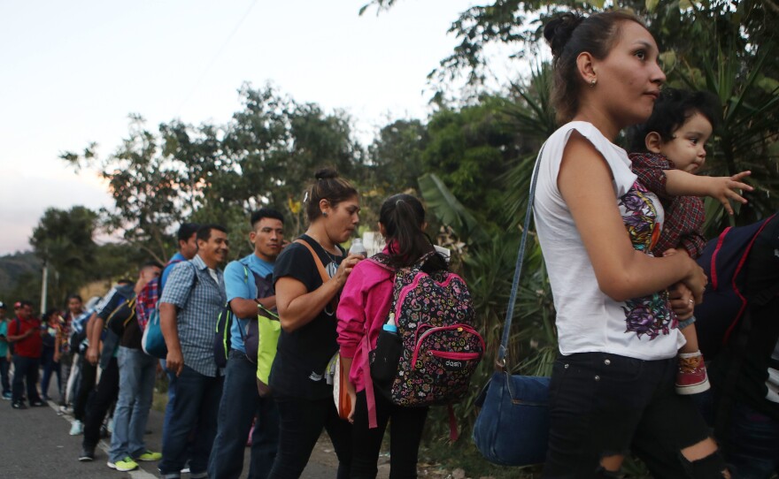 Honduran migrants wait in line to cross over the border checkpoint into Guatemala in Agua Caliente, Honduras. A new caravan of at least several hundred Hondurans has set off toward the United States on foot or in vehicles. Some have already crossed into Guatemala.