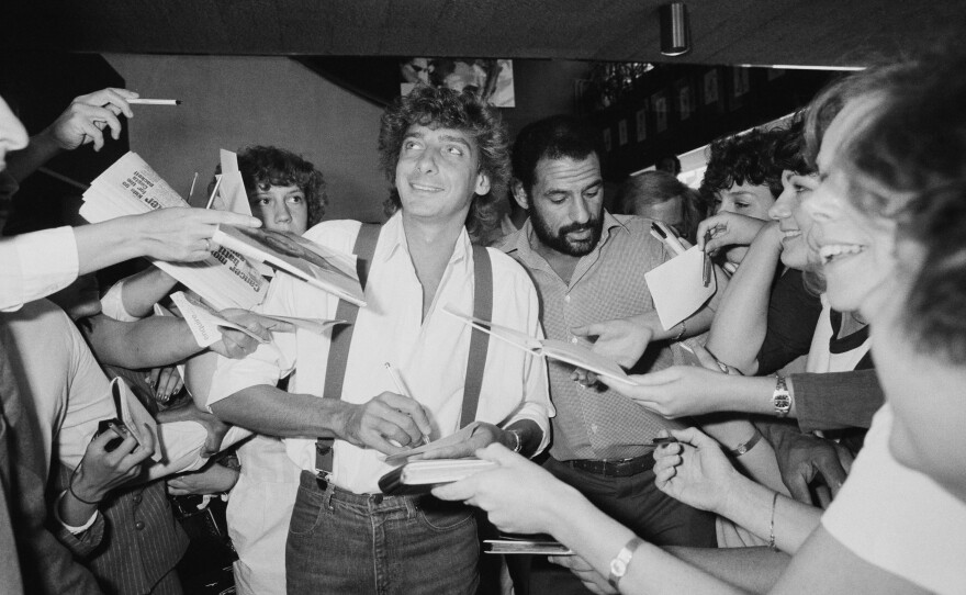 Manilow signs his autograph for fans in the U.K. in 1983.