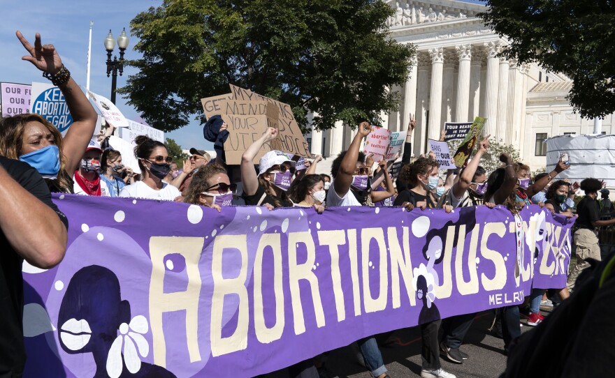 Thousands of demonstrators march outside the U.S. Supreme Court during the Women's March in Washington, Saturday, Oct. 2, 2021.