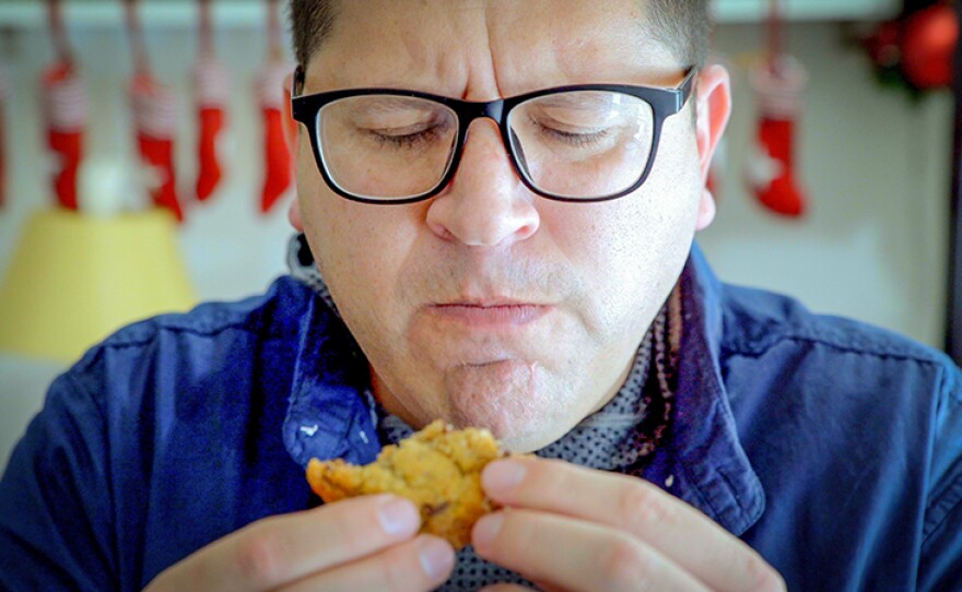 Host Jorge Meraz savors a chocolate chip cookie at La Ventanita bakery in Tijuana.