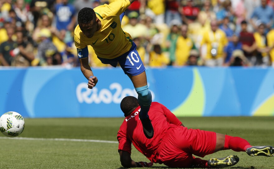 Brazil's Neymar soars over Honduras' goalkeeper Luis Lopez as he scores just 15 seconds into their semifinal game on Wednesday in Rio's Maracana Stadium. Brazil won 6-0 to advance to the gold medal game on Saturday against Germany — the team that knocked Brazil out of the 2014 World Cup with a lopsided victory.