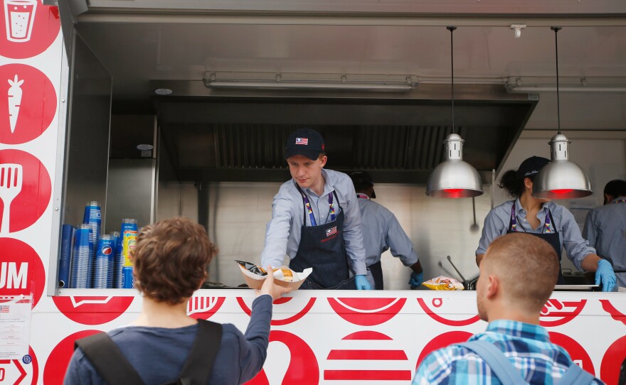 A man serves hamburgers at the USA Pavilion's food truck at Expo 2015 in Rho, near Milan, Italy. The Food Truck Nation exhibit highlights America's urban food truck trend.