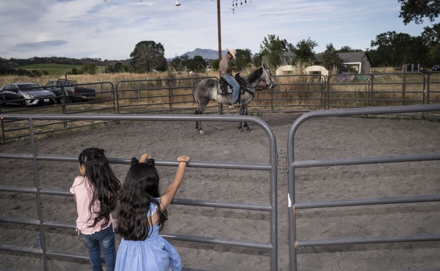 Two girls look on at a horse during Kevin's birthday party in June 2023.