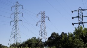 Towers for high-voltage power lines are silhouetted in the sky, Aug. 30, 2013.