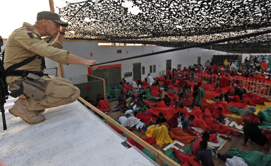 A Norwegian police officer on the bridge of the Siem Pilot ship watches over migrants rescued in the Mediterranean sea on their way to the Italian port of Cagliari on Sept. 2. Hundreds of migrants were rescued a day earlier.