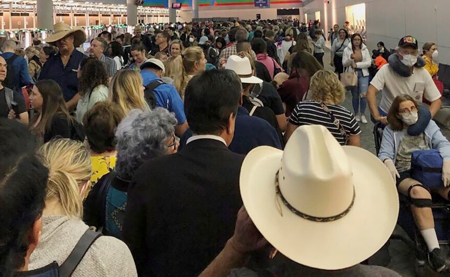 People wait in line to go through customs at Dallas/Fort Worth International Airport on Saturday. International travelers reported long customs lines at the airport Saturday as staff took extra precautions to guard against the new coronavirus.