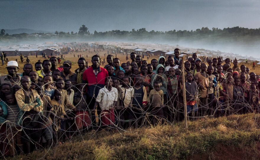 Dozens of displaced people gather along the fence of the United nations mission in the Democratic Republic of Congo.