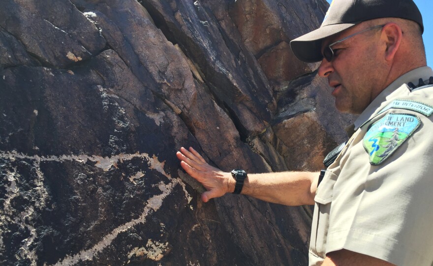 Nalen inspects a damaged petroglyph at a Native American cultural site near Pahrump, Nev.