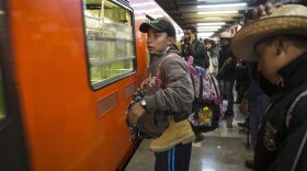 Central American migrants stand waiting for a subway car after leaving the temporary shelter in the Jesus Martinez stadium, in Mexico City, Friday, Nov. 9, 2018.