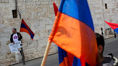 FILE - Armenians hold their national flag during a ceremony to commemorate the mass killings of Armenians by the Ottoman Empire, in Jerusalem, Israel, Friday, April 24, 2015.