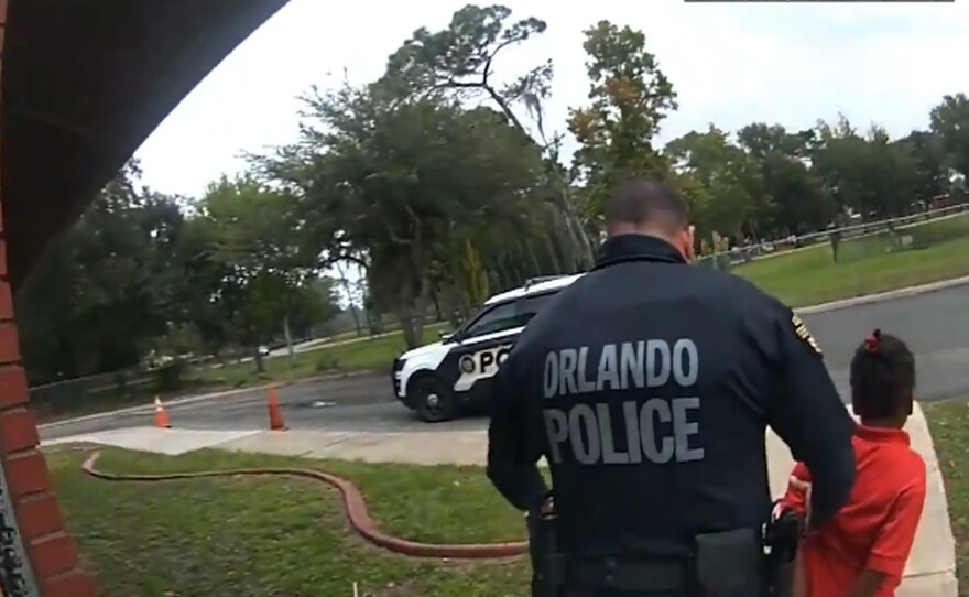 In this image taken from Sept. 19, 2019, Orlando Police Department body camera video footage, Orlando Police Officer Dennis Turner leads 6-year-old Kaia Rolle away after her arrest for kicking and punching staff members at the Lucious & Emma Nixon Academy Charter School in Orlando, Fla.