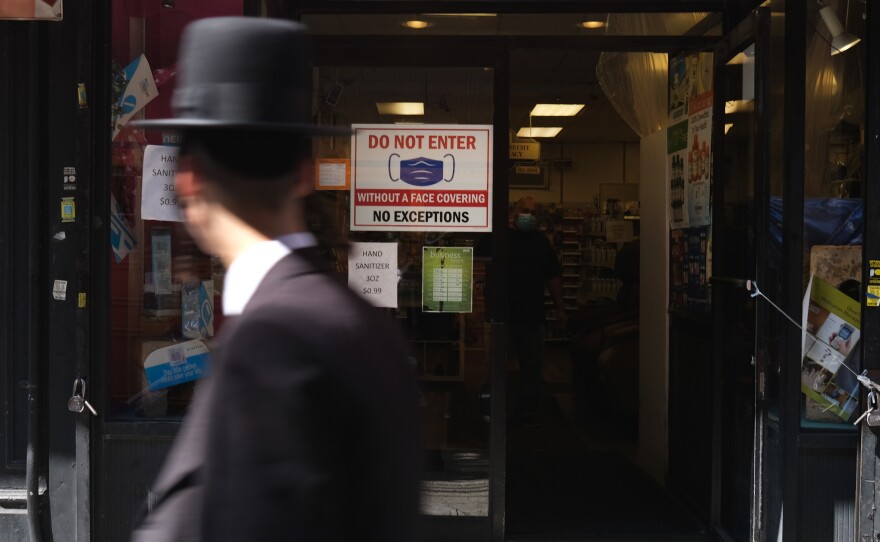Residents walk through the Brooklyn neighborhood of Borough Park on September 23 in New York City. Borough Park is one of numerous Brooklyn neighborhoods that are witnessing a spike in the number of COVID-19 cases.