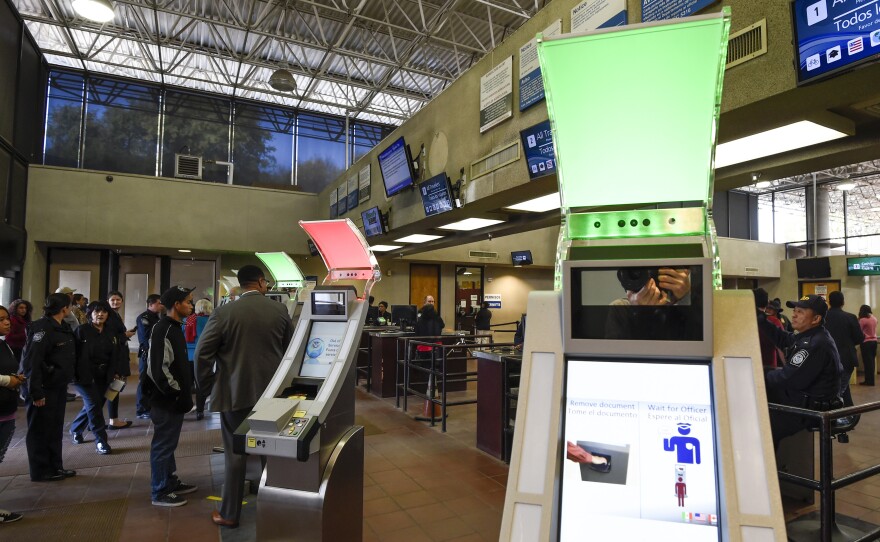 Pedestrians crossing from Mexico into the United States at the Otay Mesa Port of Entry wait to use biometric kiosks in San Diego. A new study says visa overstays exceeded illegal border crossings.