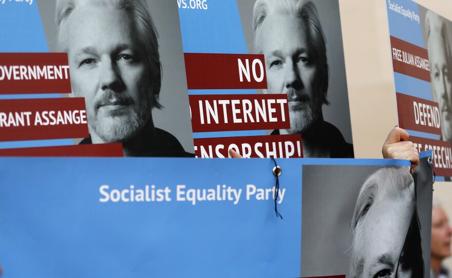 Protesters carry posters depicting Julian Assange outside Westminster Magistrates Court in London on Thursday where the WikiLeaks founder appeared by video link from prison for an extradition hearing.
