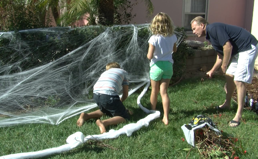 Kevin Faulconer consults with son Jack and daughter Lauren about where the Halloween decorations should go in their front yard.