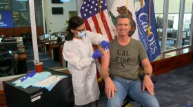 In this image taken from a live-streamed video from the California Governor's Office, California Gov. Gavin Newsom getting a flu shot during a news conference on Monday, Sept. 28, 2020, in Rancho Cordova, Calif. 