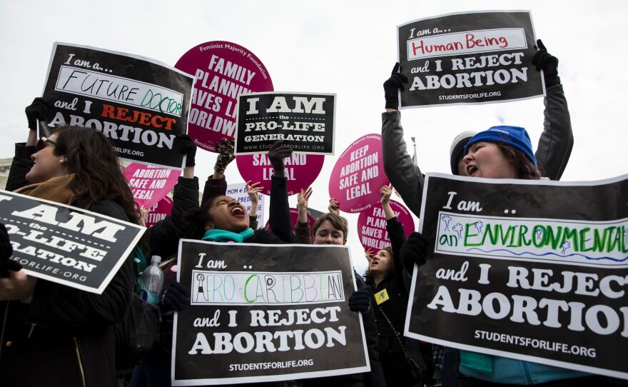 Both abortion rights opponents and abortion rights supporters protest outside the Supreme Court during the 44th annual March for Life.