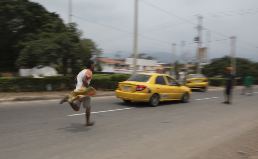 Near the border, young men and women chase after taxis, hoping to get passengers to give them some money to carry their luggage across the border.