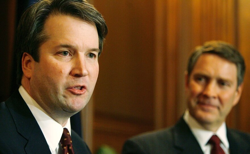 Brett Kavanaugh (left) speaks in 2006 when he was a nominee for the D.C. Circuit Court of Appeals. Then-Senate Majority Leader Bill Frist of Tennessee looks on.