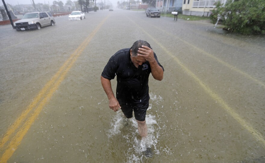 Parts of eastern Texas could see nearly 3 feet of rain through Friday, forecasters say, warning of potential flash floods from Tropical Depression Imelda. Here, Angel Marshman walks through floodwaters in Galveston after trying to start his flooded car Wednesday.