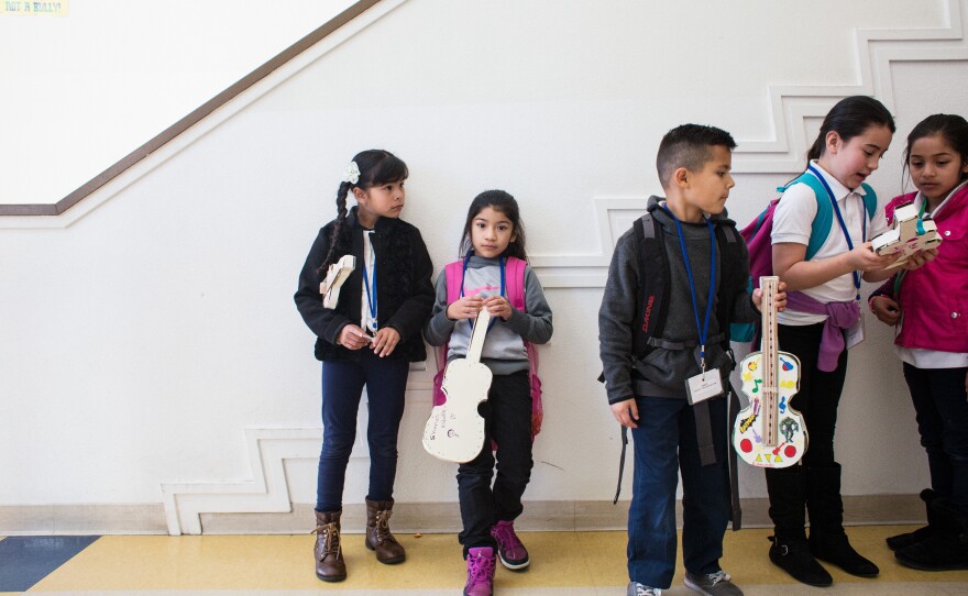 Students line up with their cardboard violins before going to their next class.