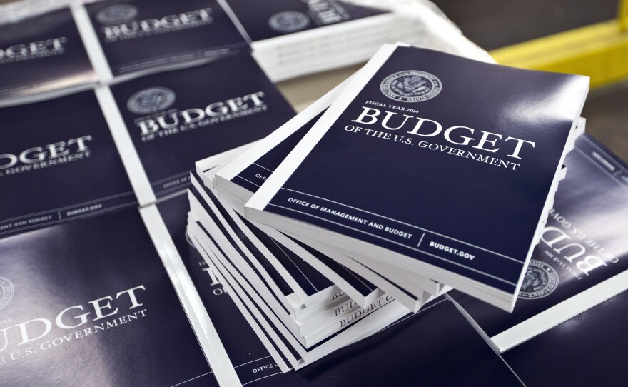 Copies of President Obama's budget plan for fiscal 2014 are prepared for delivery at the U.S. Government Printing Office in Washington in April. The Congressional Budget Office has sharply cut the outlook for the federal  deficit.