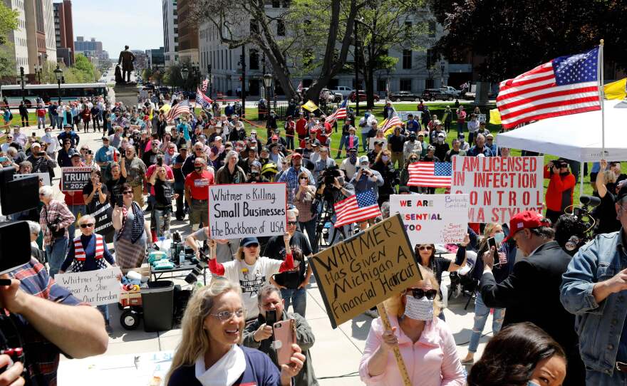 Protesters march outside the Michigan state Capitol in Lansing on May 20, denouncing Whitmer's coronavirus closures.