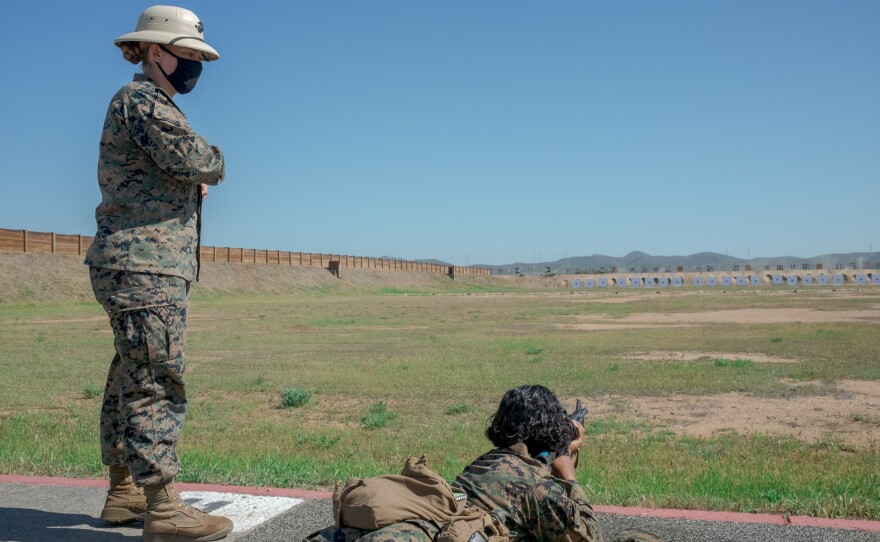 A combat marksmanship coach watches as a recruit takes a shot on the Bravo shooting range on Camp Pendleton, April 7, 2021.