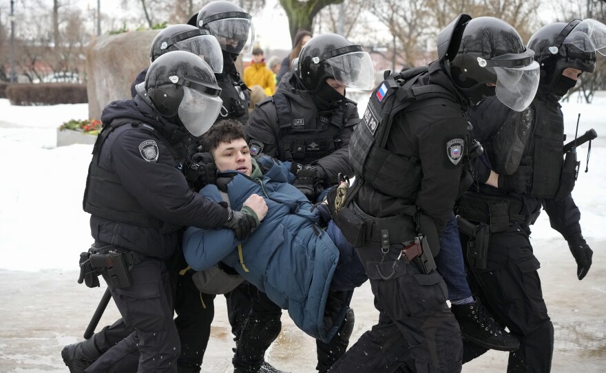 Police detain a man as he wanted to lay flowers for Alexei Navalny at a monument in St. Petersburg on Saturday.