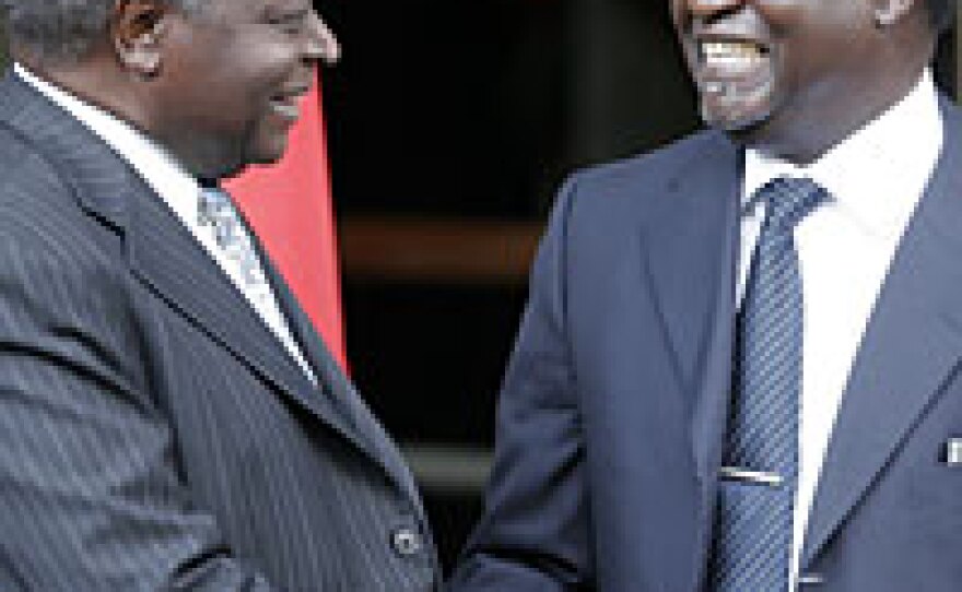 Kibaki (left) and Odinga shake hands after signing the deal.