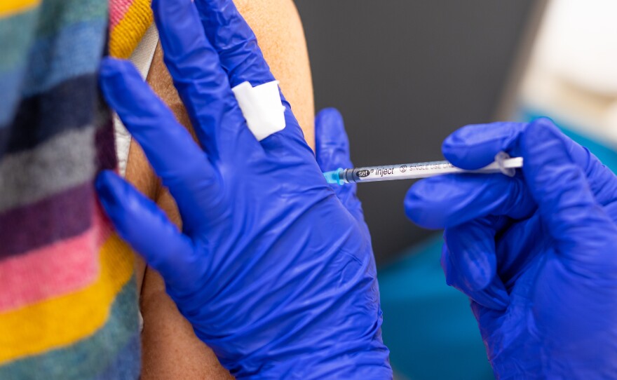 A vaccination center worker inoculates a woman with the Biontech vaccine against Covid-19 in Lower Saxony.