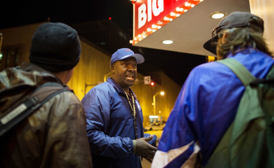 Nathan Fields talks to passersby about how to use a naloxone auto-injector to treat an opioid overdose.