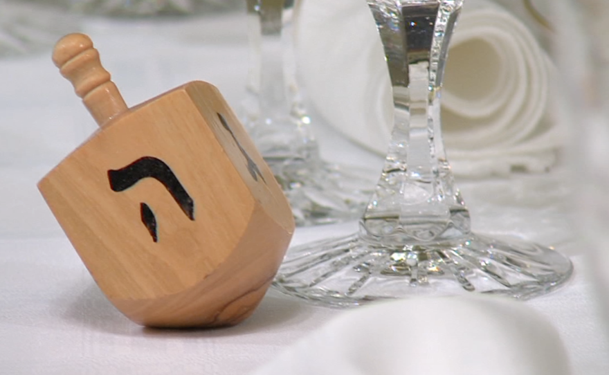 A Jewish dreidel sits next to a wine glass, Dec.10, 2015.