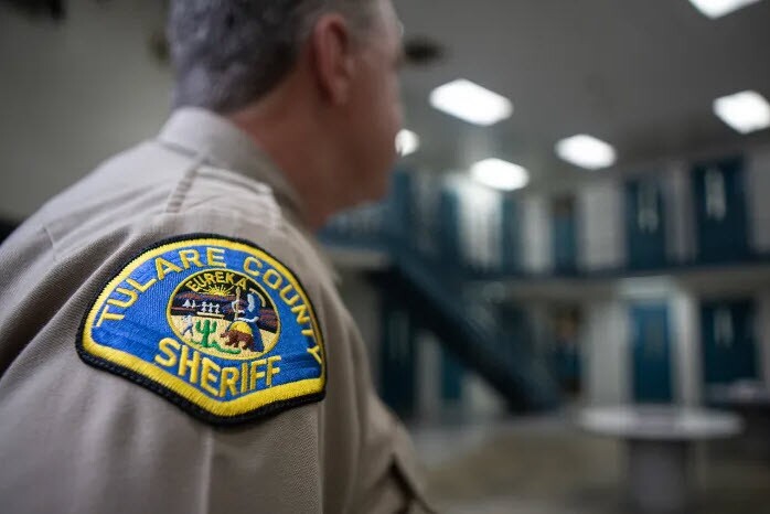 A Tulare County deputy sheriff stands guard at an inmate housing unit at the Tulare County Adult Pre-Trial Facility on Sept. 18, 2023.