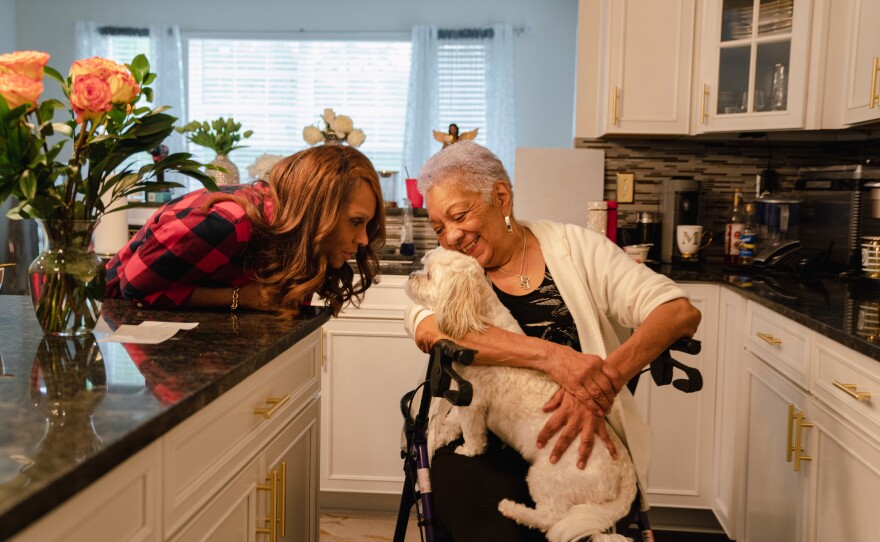 Tyrone Ferrens' wife, Michelle Ferrens, and his mother, Patricia Villa, talk to their dog Ashe.