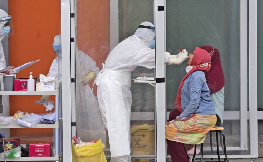 A medical worker collects nasal swab samples this week during a mass test for the coronavirus at North Sumatra University in Medan, North Sumatra, Indonesia. The mass test was held after the rector of the university along with one of his deputies and a member of the board of trustees were tested positive for COVID-19.