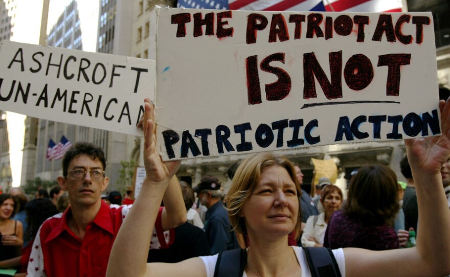 <p>Protesters hold up signs outside of Federal Hall during a demonstration against then-U.S. Attorney General John Ashcroft in 2003 in New York City. </p>