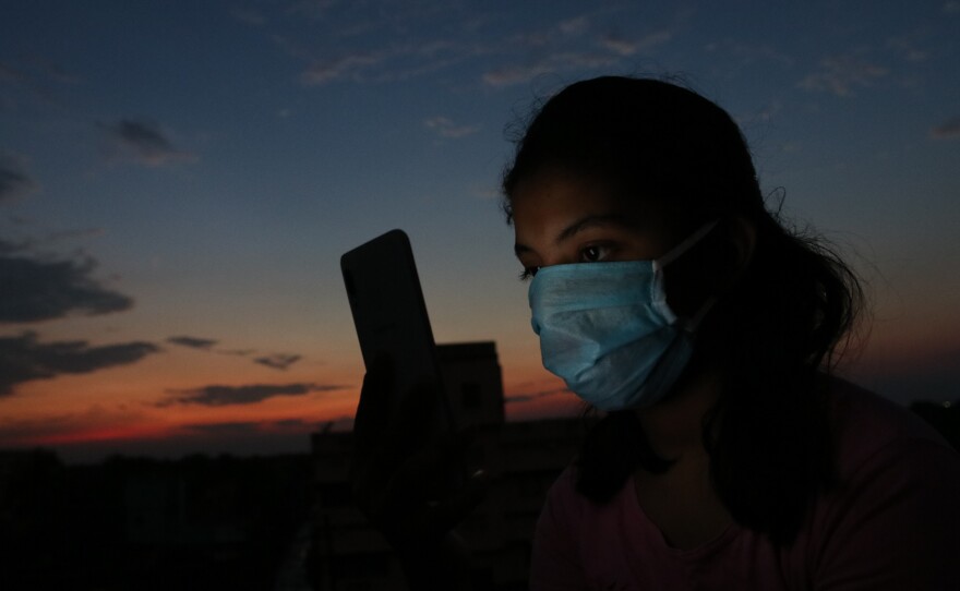 A teen girl with a smart phone in Kolkata, India, photographed in April 2020 during the government-imposed lockdown. Schools pivoted to virtual learning, which shut out many students — especially girls in low-income communities — without access to mobile devices.