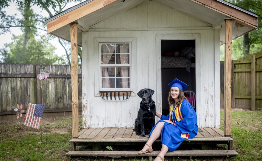 East Ascension High School Valedictorian Emma Cockrum with her dog Hercules in front of her old play house at her home in Prairieville, La.