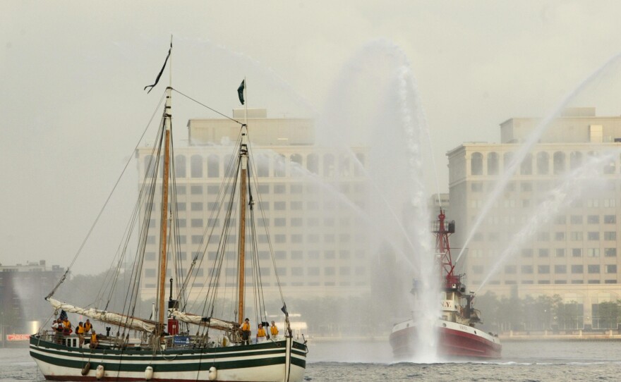 The Lois McClure (left) passes a fire boat as it arrives at the North Cove marina at the World Financial Center, Aug. 16, 2005, in New York.