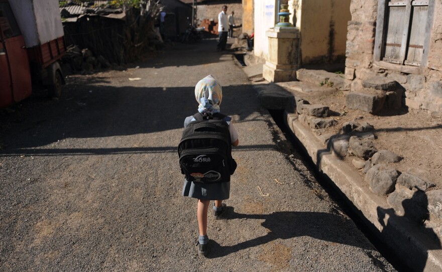 A child leaves for school in a village in India. Last November, the Indian government announced new rules limiting the weight of school bags depending on a child's age. But the rules are not always enforced.