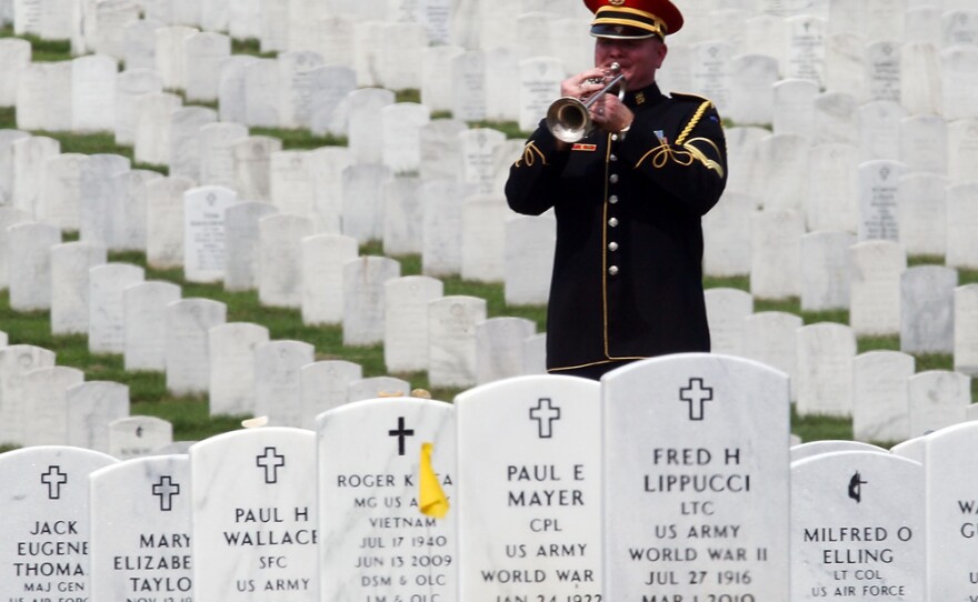 A lone bugler plays "Taps" during a burial service at Arlington National Cemetery.
