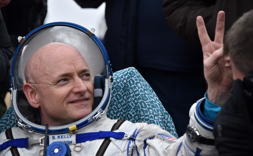 U.S. astronaut Scott Kelly shows a victory sign after landing safely on Earth after nearly a year in space.