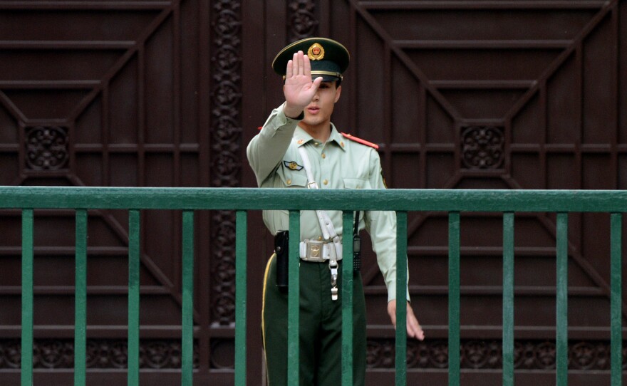 A Chinese paramilitary guard gestures outside the North Korean Embassy in Beijing on May 17. Tensions between the two countries are rising after unidentified North Koreans hijacked three Chinese fishing boats and demanded ransom, before releasing the vessels and their crew.