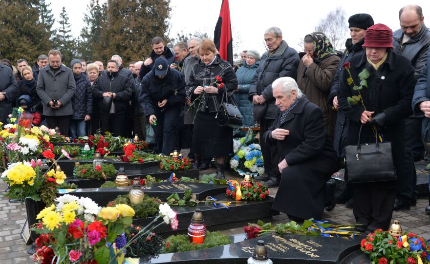 On the second anniversary of the 2014 shooting of anti-government protesters, people attend a memorial ceremony at the graves of slain Maidan activists in the western Ukrainian city of Lviv.