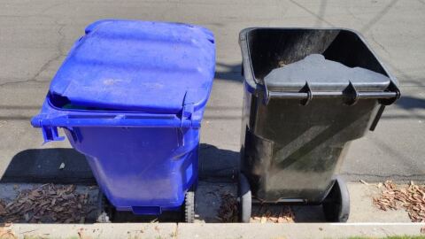 A broken San Diego trash can sits next to a recycling bin, September 5, 2019. 