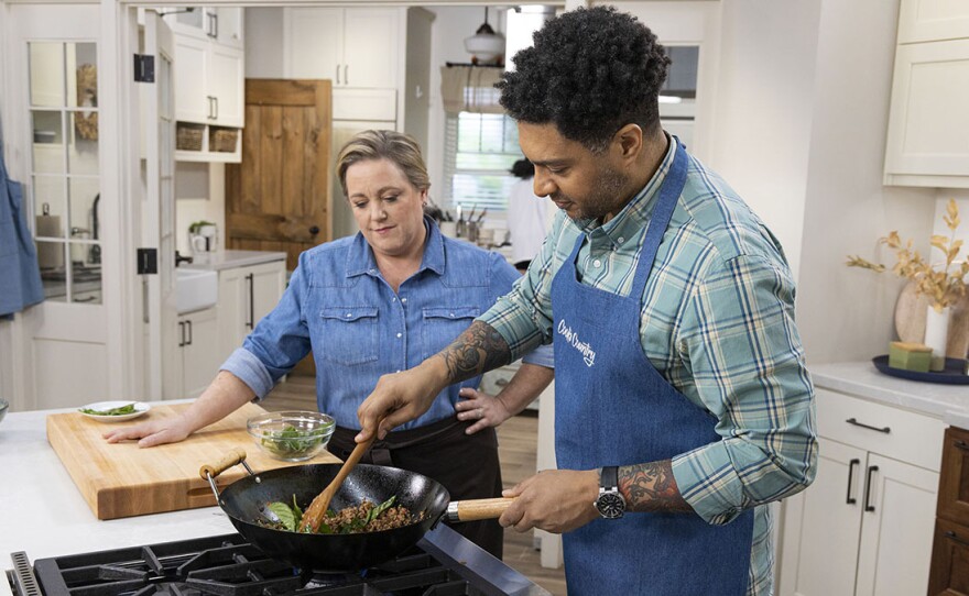 Lawman Johnson (right) makes host Julia Collin Davison (left) Pad Gra Prow (Holy Basil Stir-Fry).