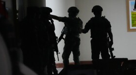 Philippine troopers exchange fire along a hallway at the Philippine Senate in Pasay, Philippines on Wednesday May 13.