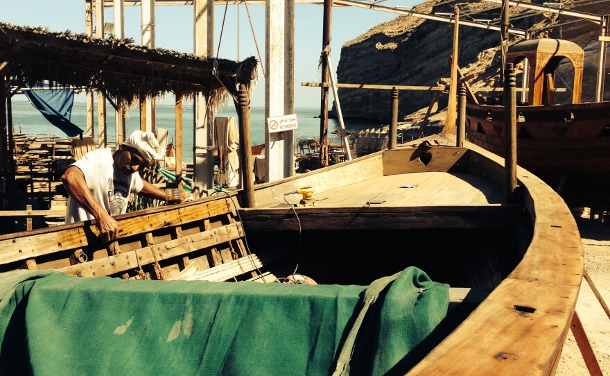 An Omani shipwright applies shark liver oil, the traditional sealant of choice, to a wooden boat at the Oman Maritime boatyard. Oman Maritime preserves the country's maritime heritage, rebuilding traditional wooden vessels from the days when Oman was part of a powerful Indian Ocean maritime trading empire.