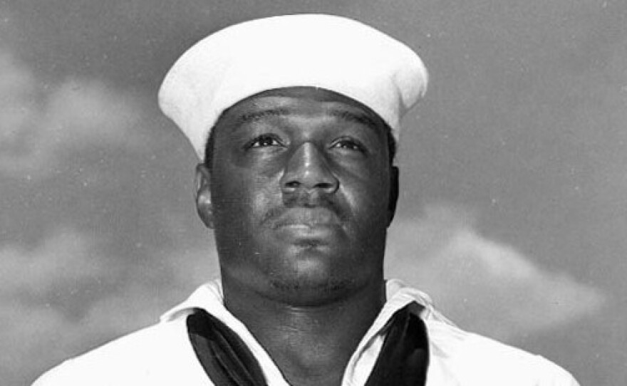 Doris "Dorie" Miller, USN Mess Attendant Second Class, May 27, 1942 after presentation of the Navy Cross by Admiral Chester W. Nimitz aboard USS Enterprise.